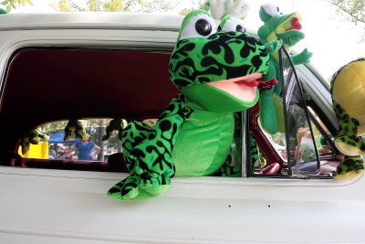 Big stuffed frog hanging out the window of a hot rod