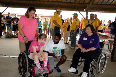 Abby Wells with mother & Amy Clark Easter Seals reps talking to Celebrity winner of frog race