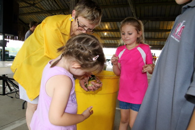 Club member holding frog so little kids can pet it