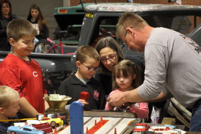 The grandchildren doing the slot car racing with the help of Mike Lowhorn