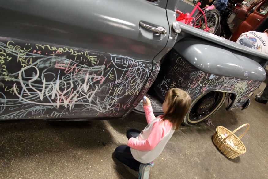 The granddaughter loved writing chaulk on the blackboard truck
